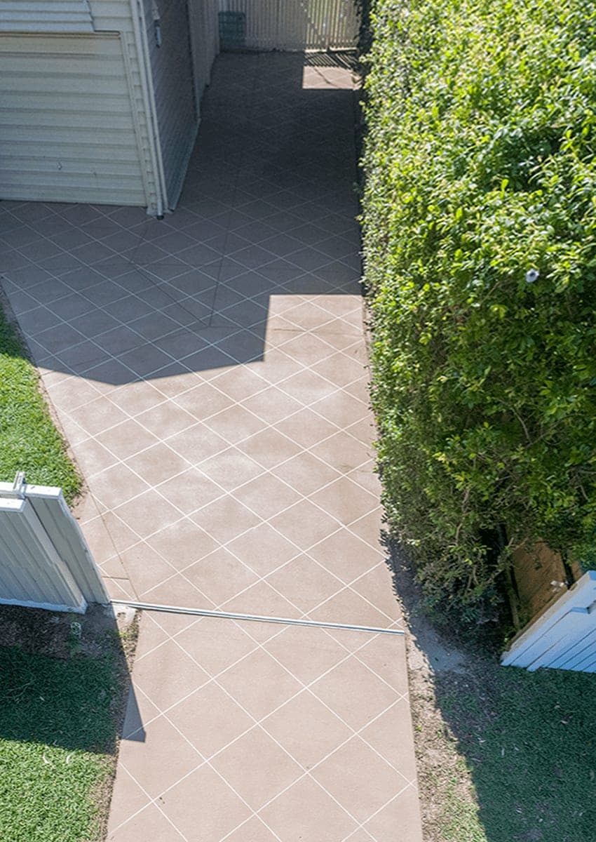After: the same side path covered in Beige Covercrete with a white angled-square Stencil.