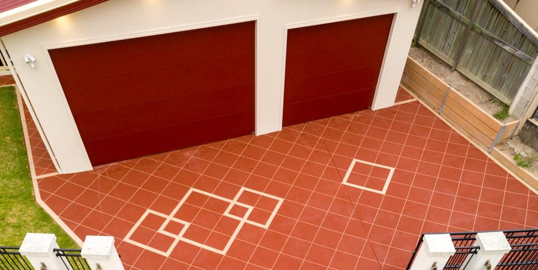 Orange Brick Covercrete in front of a double garage, with cream angled-square Stencil lines, a cream border and diamond feature panels.