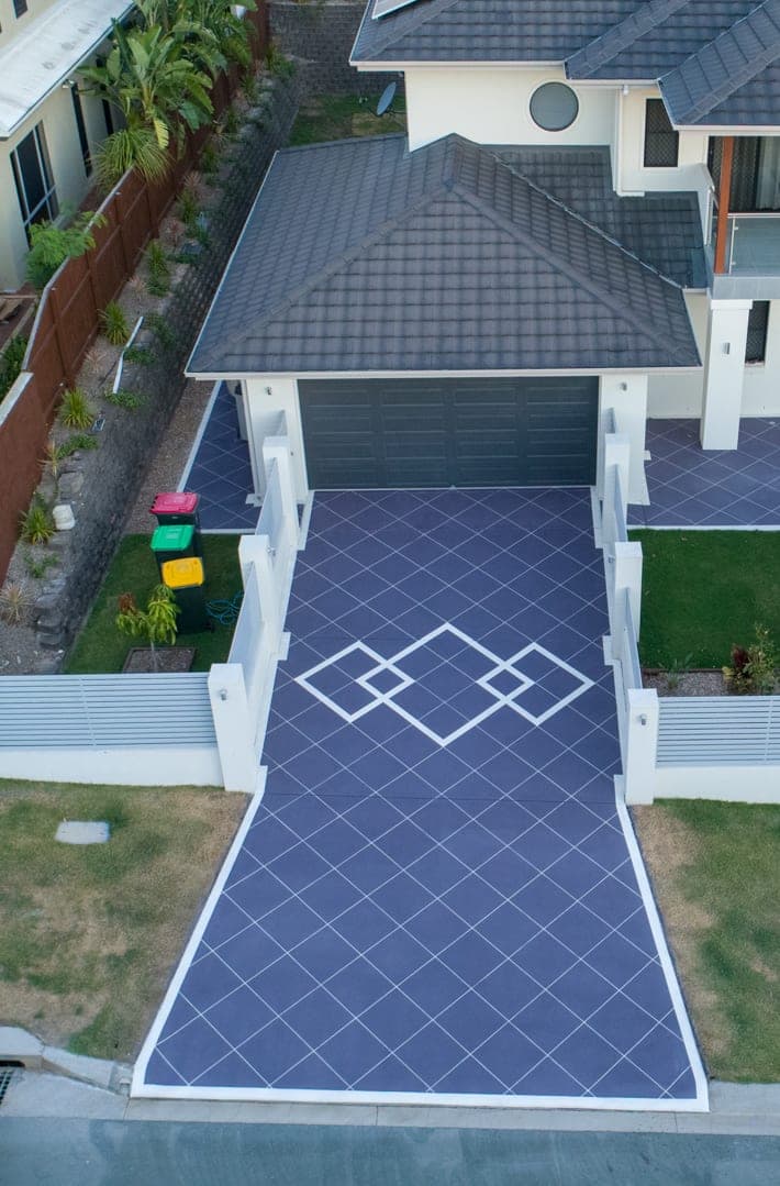 A Purple Graphite Covercrete driveway seen from above, set out in a white angled-square Stencil with a white border and overlapping diamond panels.